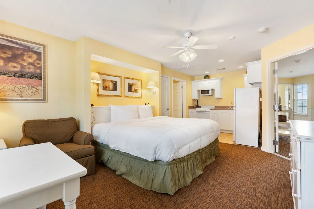 A king bedroom featuring a bed, a comfortable seating area, and a private kitchenette. The kitchenette is equipped for preparing light meals or early morning coffee, reflecting the suite's flexibility and autonomy.